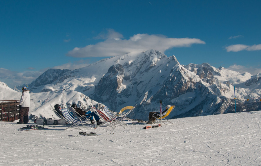 Trentino, Alto Adige, Włochy. Na tle skalistych, ośnieżonych szczytów widać leżaki, na których opalają się wypoczywający narciarze.
